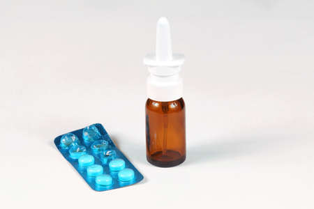 Nose drops bottle with pills medicine on white backgroundの写真素材