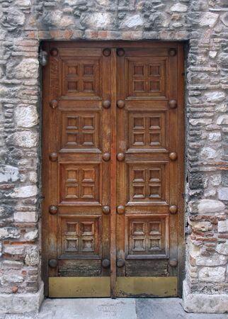 Aged wooden entrance door with stone facadeの写真素材