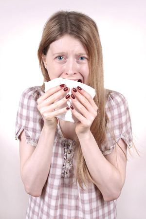 Young woman crying and holding paper tissueの写真素材