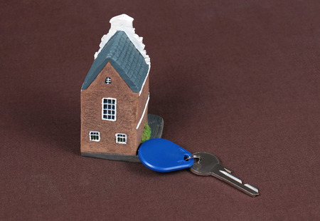 House model and key representing housing buying and mortgage marketの写真素材
