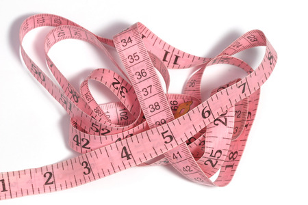 Folded pink tape measure on white backgroundの写真素材