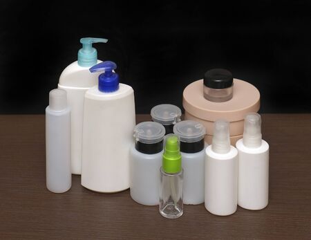 Closed empty toiletries containers on wooden shelfの写真素材