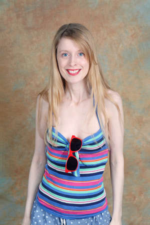 Young beautiful girl with stripe top and sunglasses wearing summer outfitの写真素材
