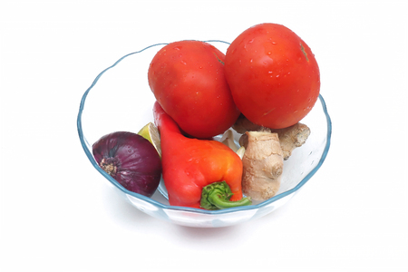 Fresh organic vegetables in glass bowl on white backgroundの写真素材