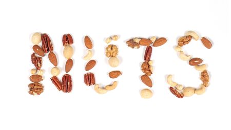 Nuts sign made of different nut seeds on white backgroundの写真素材