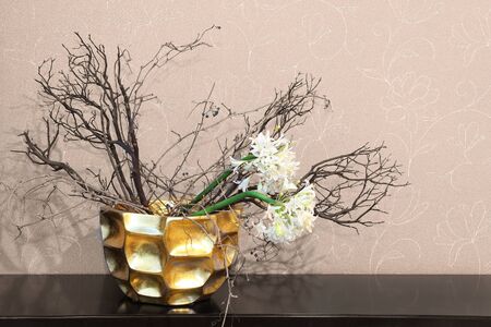 Home decor gold bowl with dry flowers on wooden tableの写真素材