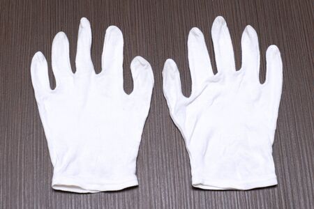White cotton gloves on wooden backgroundの写真素材