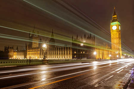 Long exposure of Westminster bridge with Big Ben and Houses of Parliament during night with beaming...