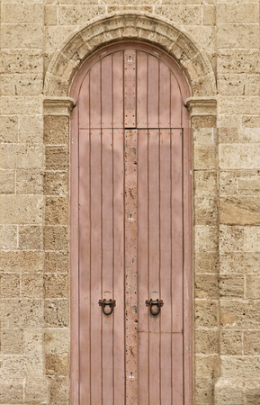 Old vintage closed wooden door on stone facade wallの写真素材