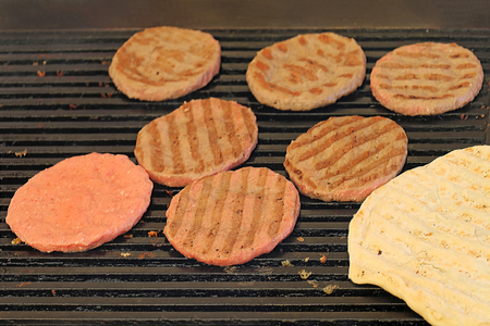 Raw red meat in burger shape for barbeque on a grill sold on local fairの写真素材