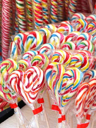 Colorful lollipops shaped as hearts inside cellophane wraps sold on local fairの写真素材