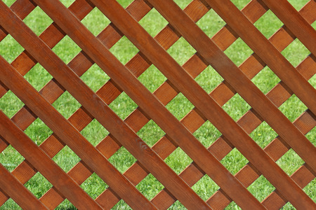 Brown wooden fence in front of green grass lawnの写真素材