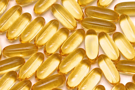Fish oil vitamin supplement yellow gel capsules pileの写真素材