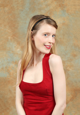 Young blonde woman with light skin in red dress wearing red lipstickの写真素材