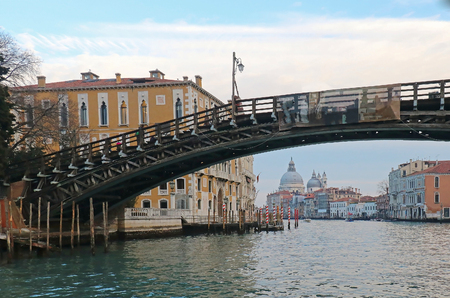 Aged fragile wooden walking bridge across Grand Canal in Veniceの写真素材