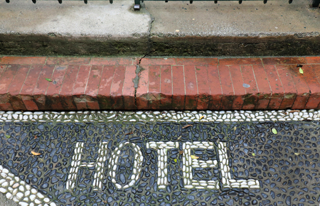 Hotel entrance sign made out of white pebbles on floorの写真素材