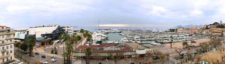 Wide panoramic view of French city Cannes with luxury yachts in port and famous landmark buildings.の写真素材