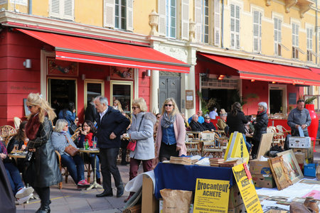 NICE, FRANCE - JANUARY 29, 2018; Antique market in Nice with people browsing through stalls looking at vintage glassware, clothing and other objects in Cannes, France. Each Monday Cours Saleya Nice is transformed into antiques and flea market, a place to のeditorial素材