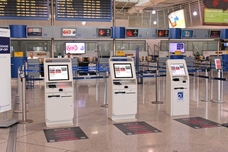 Athens, Greece - May 05, 2015: Self-service check in kiosks at Athens International Airport Eleftherios Venizelos with regular check in and baggage drop off counters staff behind.のeditorial素材
