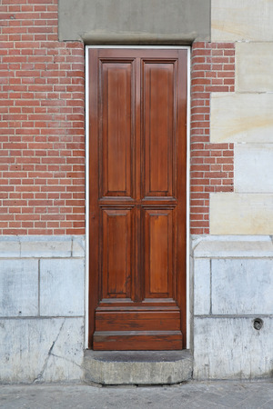 Retro narrow wooden door with brick wall facadeの写真素材