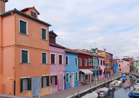 Houses with colorful facades in a canal street on Burano islandの写真素材