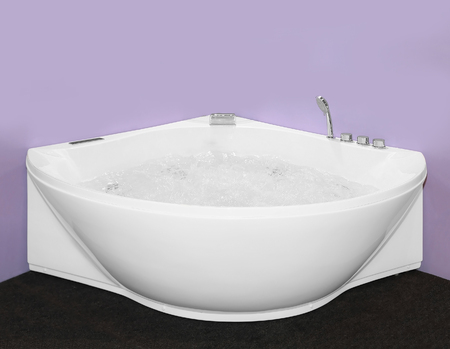 Modern bathtub filled with water in bathroom cornerの写真素材