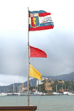 GENOA, ITALY - FEBRUARY 01, 2018: Official flag of Genoa, the capital of the Italian region of Liguria. The flag with coat of arms is flapping on wind located in Gulf of Genoa in the Ligurian Sea.のeditorial素材