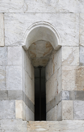 Small narrow window on old marble stone facadeの写真素材