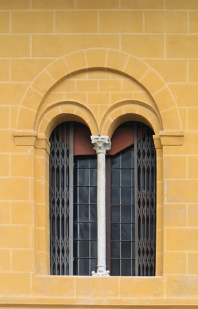 Vintage window on retro yellow brick facade and column on middleの写真素材