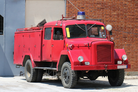 Retro fire truck in front of local fire department buildingの写真素材