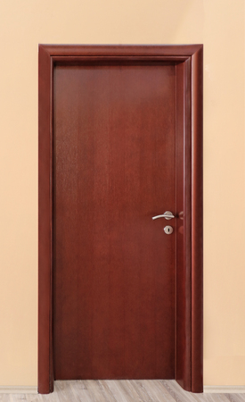 Closed interior brown wooden room door with metal handleの写真素材