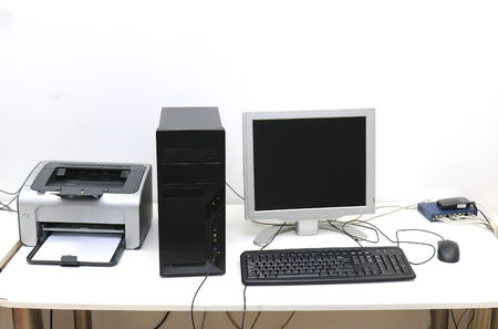 Desktop computer with display keyboard mouse and printer on deskの写真素材