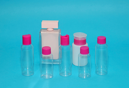 Transparent closed glass bottles with pink lids on blue backgroundの写真素材