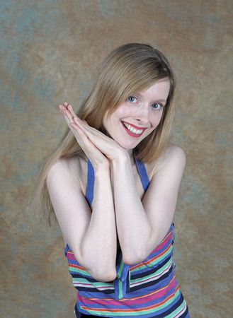 Young teenage girl with blue eyes smiling while looking to cameraの写真素材