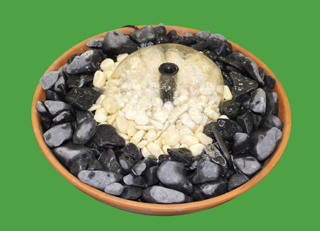 Small decorative fountain usually used for home gardens isolated on green backgroundの写真素材