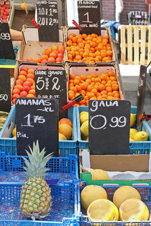 Small fresh organic fruits market stall with piles in plastic cratesの写真素材