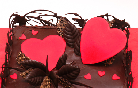 Dark chocolate cake with red hearts decorative ornamentsの写真素材