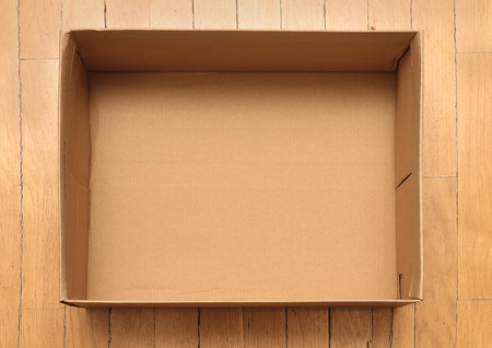 Empty cardboard rectangle box on wooden floorの写真素材
