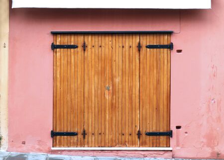 Retro closed garage wooden door on house with pink facade wallの写真素材