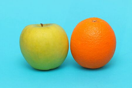 Apple and orange fresh organic fruits on blue backgroundの写真素材