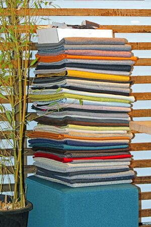 Large pile of textile fashion scarves stacked in corner of wardrobeの写真素材