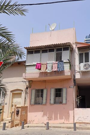 Old house windows on faded facade in Israelの写真素材