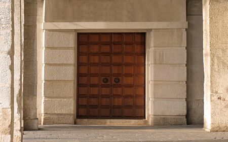 Closed ancient wooden double door with old stone facadeの写真素材