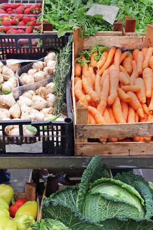 Fresh organic food piles in crates sold on market stallの写真素材