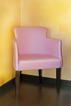 Modern leather pink chair inside empty interior room with yellow wallsの写真素材