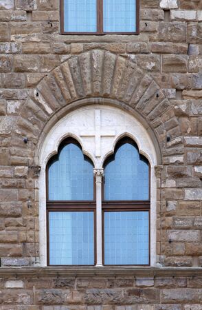 Aged stone facade closed window exterior with decorative glassの写真素材