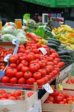 Fresh organic vegetables piles sold on market stall from wooden cratesの写真素材