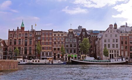 Traditional buildings architecture in Amsterdam canal waterの写真素材