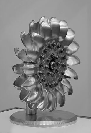 Central silver metal turbine machine part with gray wall backgroundの写真素材