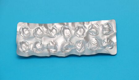 Empty used silver blister without medicine pills on blue backgroundの写真素材